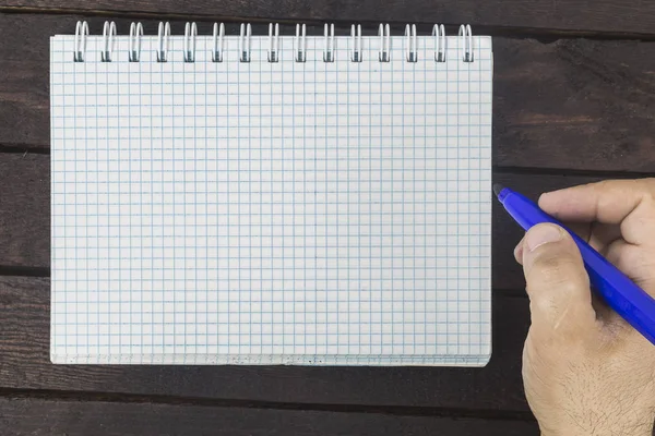 Mano masculina está escribiendo en bloc de notas en blanco — Foto de Stock