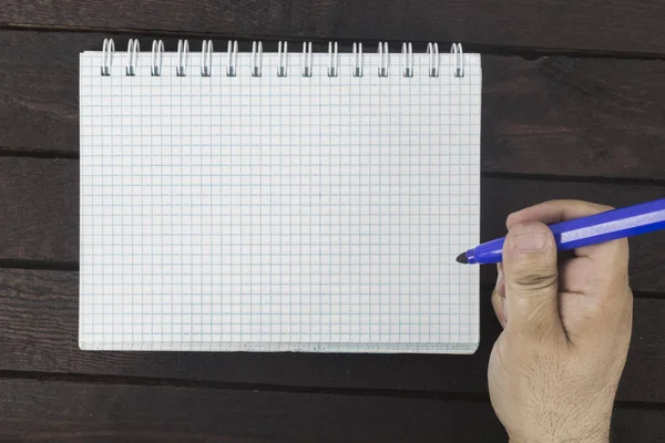 Mano masculina está escribiendo en bloc de notas en blanco — Foto de Stock