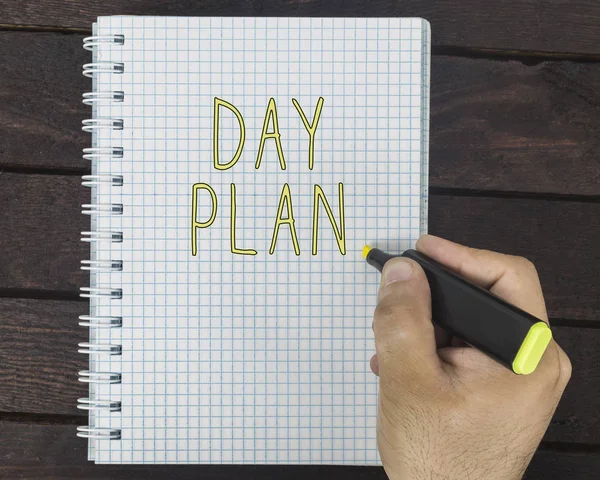 Mão masculina está escrevendo plano Dia em um bloco de notas — Fotografia de Stock