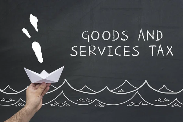 Finanzas, impuestos, concepto de negocio. buque de papel de vela de mano con texto: impuesto sobre bienes y servicios — Foto de Stock