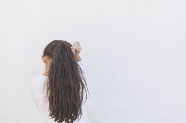 Hayal kırıklığına uğramış küçük bir kız üzgün ve alıngan. Kaybolmuş ya da ailesi tarafından gücendirilmiş genç bir bayanın arka görüntüsü. Güzel liseli kız başını yana çeviriyor.
