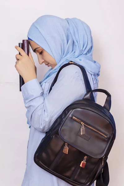 Modern Muslim student girl in hijab. Young middle-eastern college student with backpack holding books and notepads. Isolated on white background. Portrait of young Arabian woman student