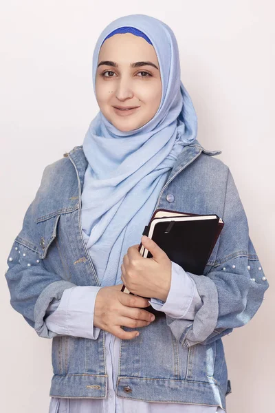 Retrato de mulher de negócios muçulmana bonito. Estudante muçulmano atraente segurando blocos de notas. Menina muçulmana adorável em hijab e casaco de ganga. Conceito moderno, cultural, religioso e empresarial — Fotografia de Stock