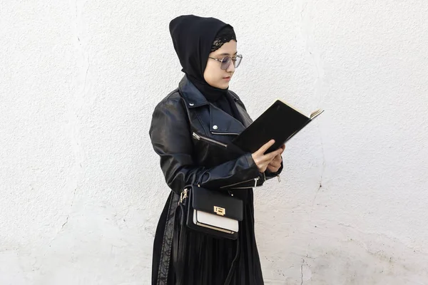 중동의 젊은 여학생 이 수첩 과 핸드백을 들고 있습니다. 전통적 인 이슬람 복장의 히잡을 입고 있는 현대 이슬람 여성 — 스톡 사진