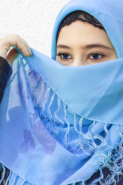 Retrato de close-up da bela menina iraniana com olhos azuis. Mulher muçulmana atraente em hijab cobrindo seu rosto com cachecol — Fotografia de Stock