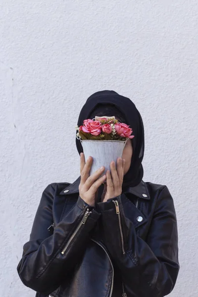 Gyönyörű közel-keleti lány kezében dekoratív kosár tele virágokkal. Aranyos arab muszlim nő kapott egyedi virágcsokrot ajándékba születésnapjára — Stock Fotó
