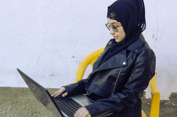 아름다운 중동 지역 사람들 이 노트북을 가지고 작업하고 있습니다. 히잡에 있는 귀여운 아라비아 이슬람 여성 이 노트북을 들고 밖에 포즈를 취하고 있습니다. 블로거, 블로거, 프리랜서 일하는 여자 — 스톡 사진
