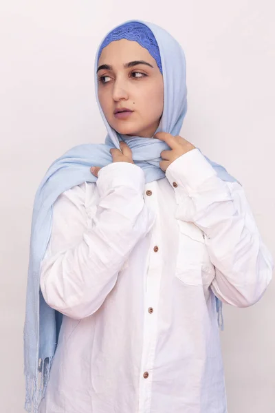 穿着白衬衫和浅蓝色头巾的优雅的穆斯林妇女。 穿着穆斯林服装的时髦的伊朗女孩。 有吸引力的中东女人的孤立画像 — 图库照片