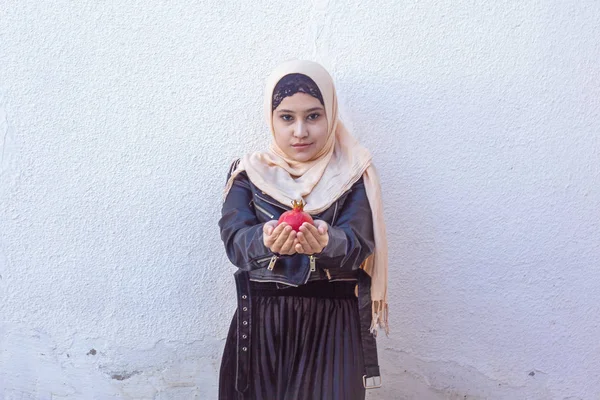 Beautiful middle-eastern girl holding pomegranate fruit. Cute Arabian Muslim woman received unique present — Stock Photo, Image