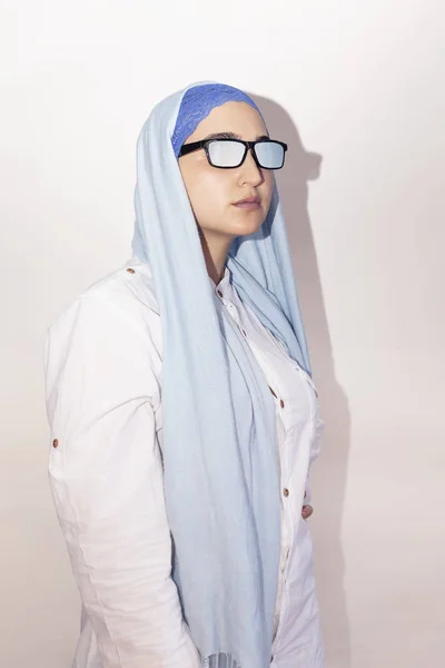 Stylish and elegant Muslim woman in traditional Islamic clothing. Portrait of beautiful Iranian girl in hijab and trendy sunglasses. Stock photo of Islamic clothing, fashion