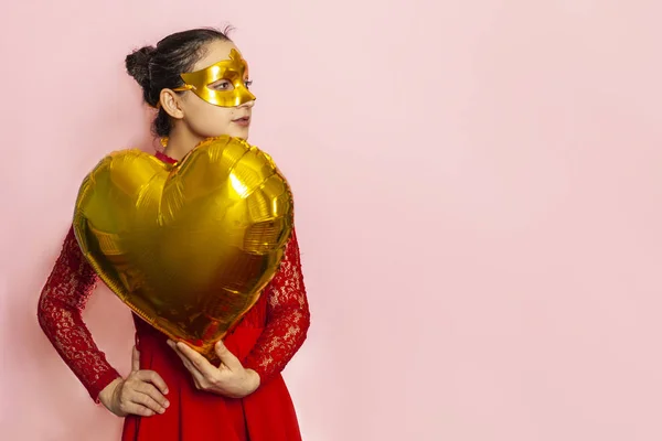 Egy nő álarcos maszkot visel és szív alakú léggömböt tart. Valentin-nap, Születésnap, Évforduló, Ünnepi, Bál ünnepi koncepciók — Stock Fotó