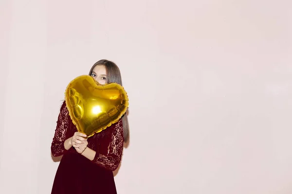 Fiatal gyönyörű lány átöleli szív alakú arany léggömb. Valentin-nap, születésnap, nőnap, évforduló, ünnep ünnep koncepció — Stock Fotó