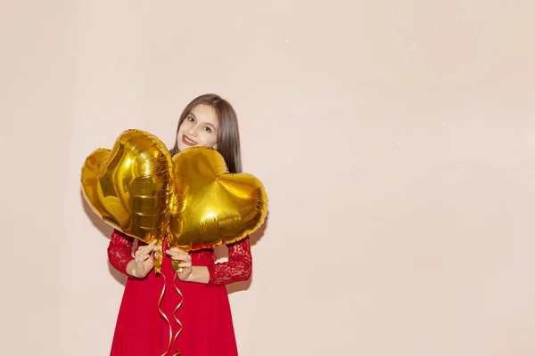 Woman holds heart shaped golden air balloons. valentines day, birthday, womens day, anniversary, holiday celebration concept — Stock Photo, Image