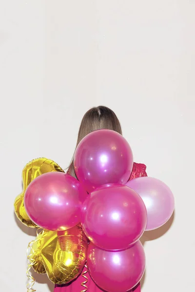 Femme se tient derrière tenant tas de ballons à air coloré . — Photo