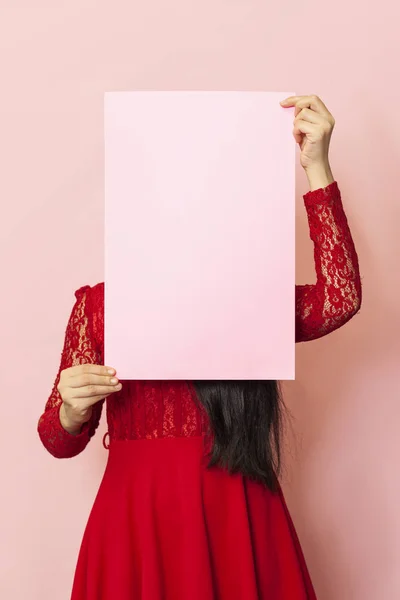 戴面具的年轻漂亮女人拿着一张空卡片。 20多岁的中东女性持空白纸。 广告，横幅 — 图库照片