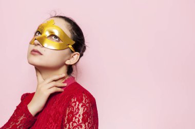 Gece elbisesi ve altın maskeli güzel bir kadının portresi. Sevgililer günü, karnaval, şenlik balosu, doğum günü kutlaması konsepti. Genç bir bayanın yüz ifadeleri