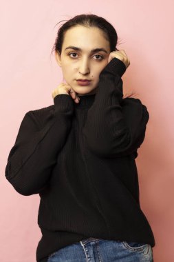 Gündelik giysiler içinde genç ve şık bir orta doğulu kadının portresi. Çekici bir kadın stüdyoda poz veriyor.