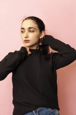 Gündelik giysiler içinde genç ve şık bir orta doğulu kadının portresi. Çekici bir kadın stüdyoda poz veriyor.