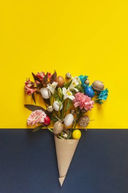 Renkli paskalya yumurtalarıyla dolu parlak bahar çiçekleri.