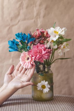 Renkli bahar çiçeklerine dokunan kadın