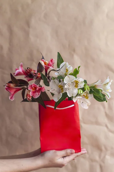 Flower shop. Giving flowers. Hands holding spring flowers bouquet