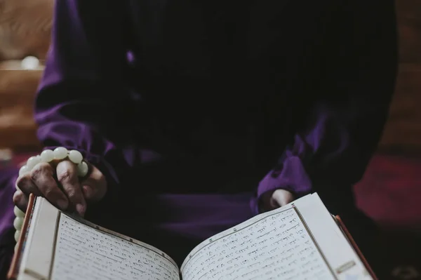 Rezando joven musulmana. Chica de Oriente Medio rezando y leyendo el Sagrado Corán. Mujer musulmana estudiando El Corán — Foto de Stock