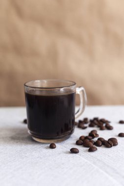 Bir fincan sade kahve ve mermer arka planda fasulye.