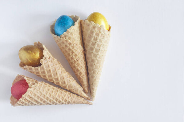 Happy easter concept. Easter festive background. Ice cream cone and bright colorful decorated easter eggs on the white background. Top view