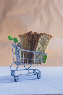 Alışveriş arabasında dilimlenmiş ekmek. Yakın çekim. Ekmeğin fiyatı değişiyor. Ekmek fiyatlarının artması veya düşmesi
