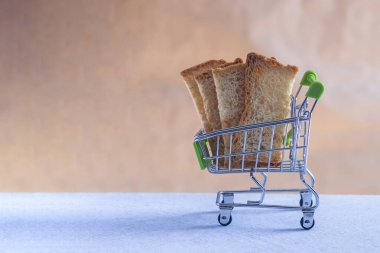 Alışveriş arabasında dilimlenmiş ekmek. Yakın çekim. Ekmeğin fiyatı değişiyor. Ekmek fiyatlarının artması veya düşmesi