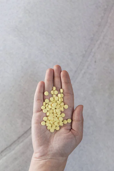 Γυναίκα Που Κρατάει Κίτρινα Χάπια Στο Χέρι Άνω Όψη — Φωτογραφία Αρχείου
