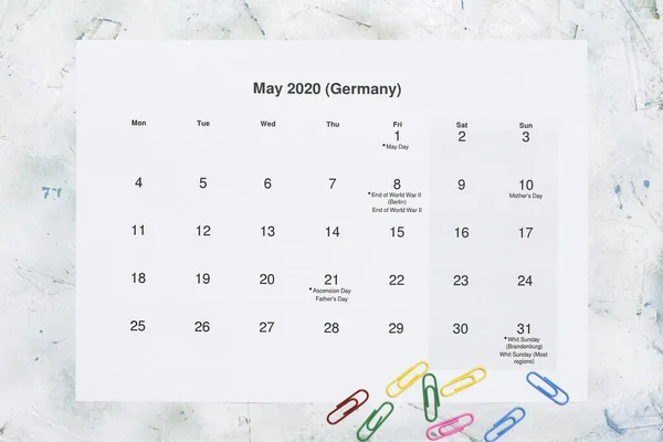 Monatskalender Mai 2020. Translation: Monthly May 2020 calendar. Paper May month calendar in Dutch. Top view