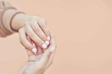 Tanınmaz bir kadın kolu. Tırnaklarında manikür olan güzel ellerini gösteren bir kadın. Şık moda kadın manikürü. Güzellik konsepti. El bakımı