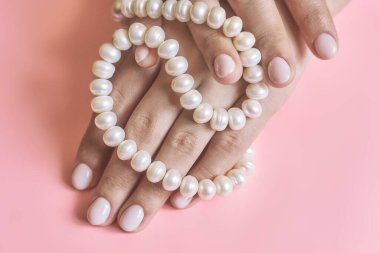 Manikürlü, incili güzel kadın elleri. Modaya uygun kadın manikürü yapan bir kadın. El bakımı