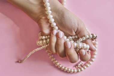 Manikürlü, incili güzel kadın elleri. Modaya uygun kadın manikürü yapan bir kadın. El bakımı