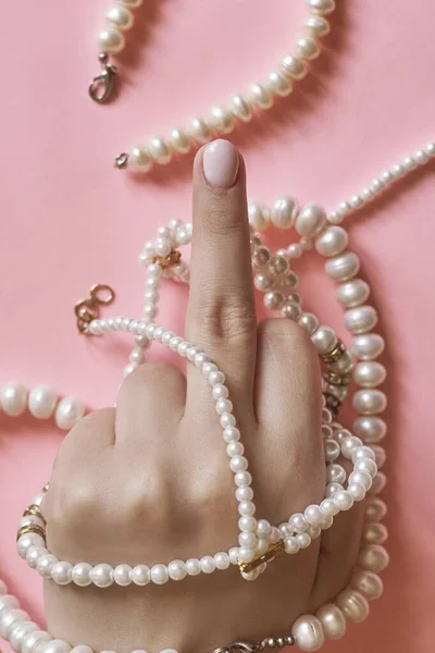 Beautiful female hands with manicure holding pearls. Woman showing hands with stylish trendy female manicure. Hand skin care