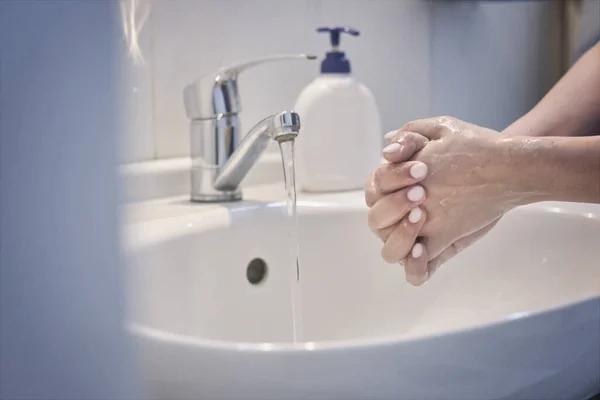 Woman washing hands with soap. An unrecognizable female showing how to wash hands properly. Coronavirus or COVID-19 prevention