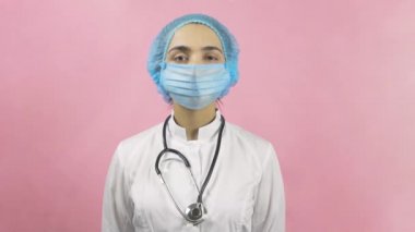 Tıbbi maske takan kadın doktor kameraya bakıyor. Bilim adamı ya da virolog. Sağlık hizmetleri çalışanı. Covid 19