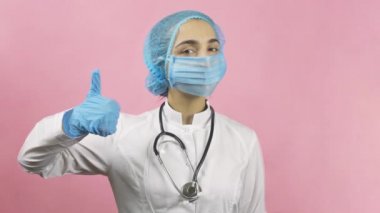 Tıbbi maske takan kadın doktor ve tıbbi eldivenler el hareketini onaylıyor. Merak etme, mutlu ol. Covid-19 'dan ya da salgın sonrası dönemden sonra. Coronavirus 'a karşı zaferi kutluyoruz.