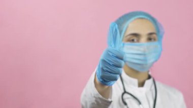 Tıbbi maske takan kadın doktor ve tıbbi eldivenler el hareketini onaylıyor. Merak etme, mutlu ol. Covid-19 'dan ya da salgın sonrası dönemden sonra. Coronavirus 'a karşı zaferi kutluyoruz.