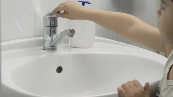 Een kleine jongen wast zijn handen. 7-jarige jongen toont handen wassen — Stockvideo