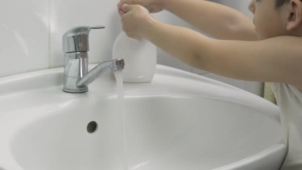 Een kleine jongen wast zijn handen. 7-jarige jongen toont handen wassen — Stockvideo