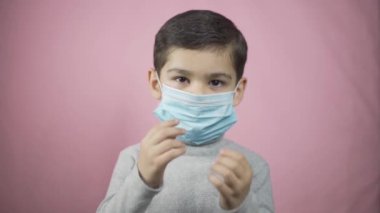 Tıbbi maske takan anaokulu çocuğu.