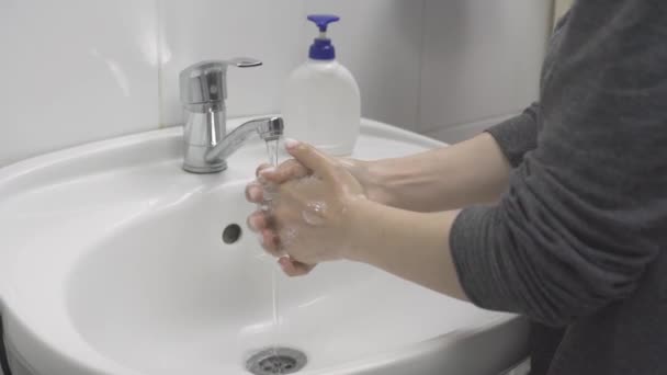 Een vrouw wast haar handen. Vrouw laat zien hoe om handen te wassen — Stockvideo