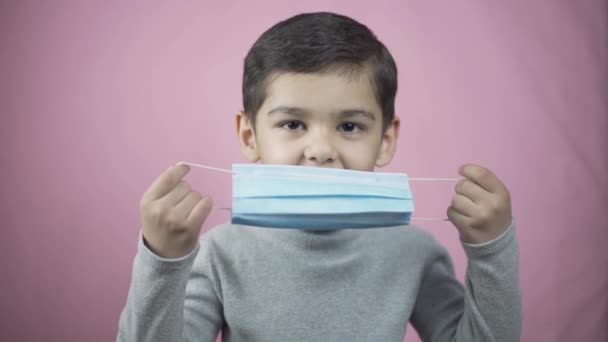 Хлопчик-дошкільник у медичній масці для обличчя — стокове відео