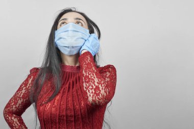 Gece elbisesi ve cerrahi maske takan genç bir orta doğulu kadın. Cerrahi maskeli güzel kadın kutlama yapıyor. Karantina sırasında covid-19 salgınına karşı eğlenen orta yaşlı kadın portresi
