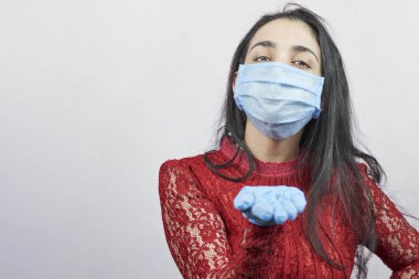 Gece elbisesi ve cerrahi maske takan genç bir orta doğulu kadın. Cerrahi maskeli güzel kadın kutlama yapıyor. Karantina sırasında covid-19 salgınına karşı eğlenen orta yaşlı kadın portresi