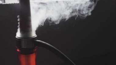Yakın plan nargile görüntüsü nargile barında duman üflüyor.