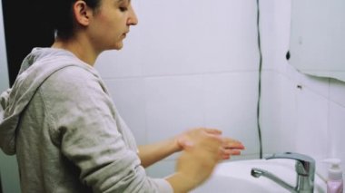 Her gün yüz yıkama rutini. Kadın yüzünü özel temizleme jeliyle yıkıyor. Genç bir kadın cildini nemlendirici yüz yıkama ile temizliyor.