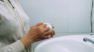 Banyoda makyaj maskesi takan bir kadın. Karışık ırk dişileri yüzüne beyaz besleyici maske ya da krem sürerler. Yüzüne maske takıyorum. Cilt temizleme spa rahatlama konsepti